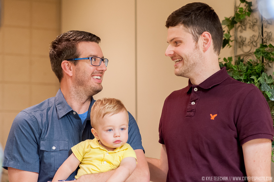 Newlywed couple Eric Evans, holding son Sawyer, on left, and Adam White look at each other on Wednesday after becoming the first gay couple to wed in Lake County.